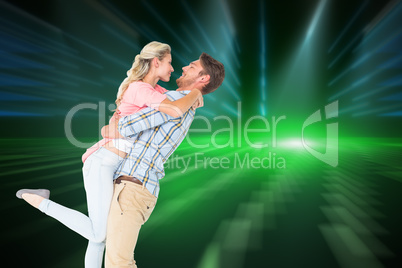 Composite image of handsome man picking up and hugging his girlf