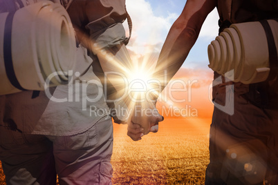 Composite image of hitch hiking couple standing holding hands on