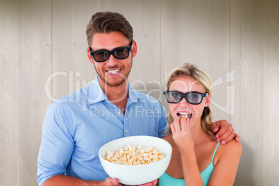 Composite image of happy young couple wearing 3d glasses eating