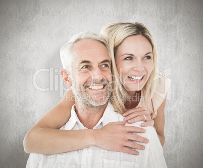 Composite image of happy man giving his partner a piggy back