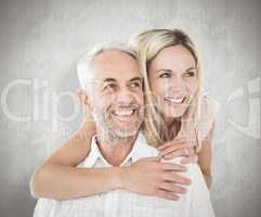 Composite image of happy man giving his partner a piggy back