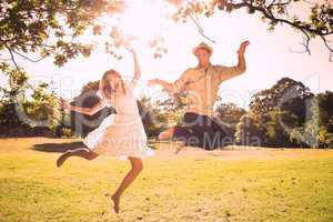 Cute couple jumping in the park together