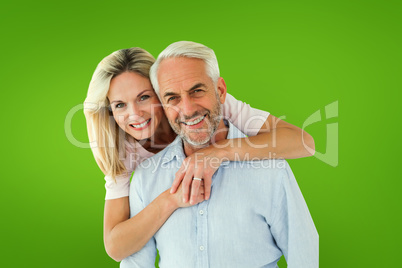 Composite image of smiling couple embracing and looking at camer