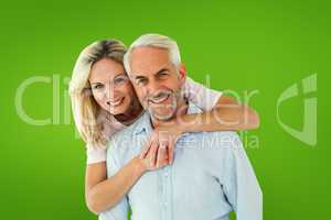 Composite image of smiling couple embracing and looking at camer