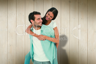 Composite image of happy casual man giving pretty girlfriend pig