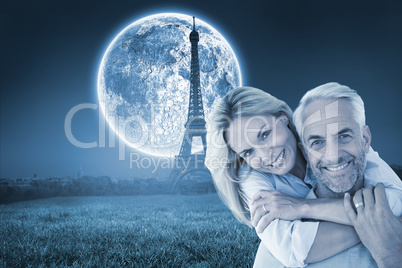 Composite image of happy couple standing and hugging