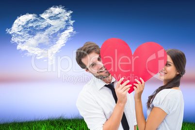 Composite image of couple smiling at camera holding a heart