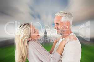 Composite image of happy couple standing and hugging