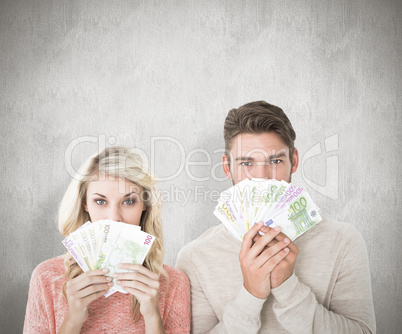 Composite image of attractive couple flashing their cash