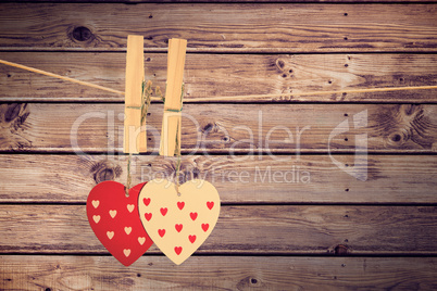 Composite image of hearts hanging on the line