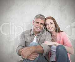 Composite image of casual couple sitting and smiling