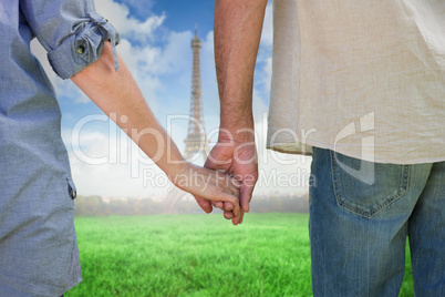 Composite image of couple holding hands in park