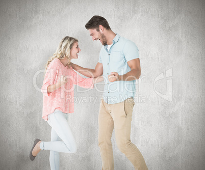 Composite image of attractive couple smiling and cheering