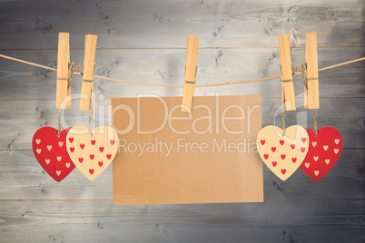 Composite image of hearts hanging on line with card