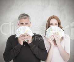 Composite image of casual couple showing their cash