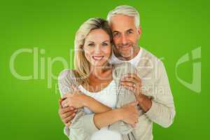 Composite image of happy couple standing and hugging