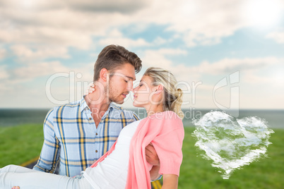 Composite image of handsome man picking up and hugging his girlf