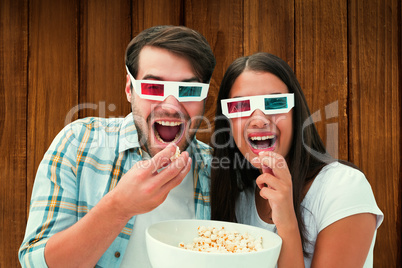 Composite image of attractive young couple watching a 3d movie