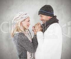 Composite image of couple in winter fashion embracing