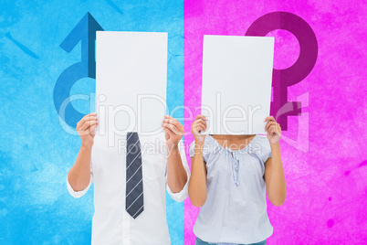 Composite image of couple holding paper over their faces