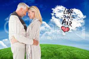 Composite image of happy couple standing and hugging