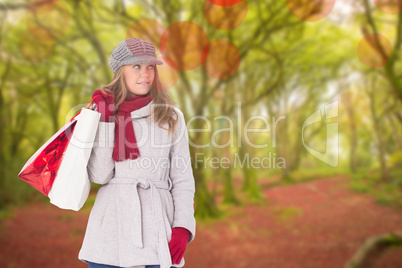 Composite image of happy blonde in winter clothes with bags