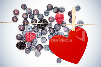 Composite image of heart hanging on line