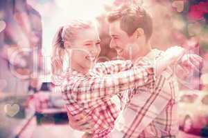 Couple in check shirts and denim hugging each other