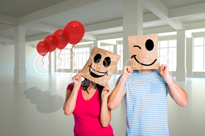 Composite image of young couple with bags over heads