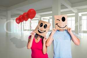 Composite image of young couple with bags over heads