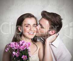 Composite image of man kissing woman as she holds flowers