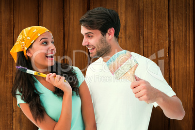 Composite image of happy young couple painting together and laug