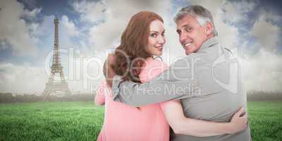 Composite image of casual couple standing arms around