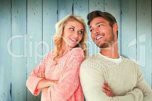 Composite image of attractive couple smiling with arms crossed