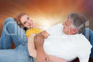 Composite image of casual couple lying on floor