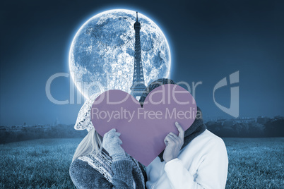 Composite image of couple in winter fashion posing with heart sh