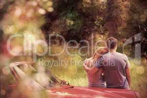 Loving couple admiring nature while leaning on their cabriolet