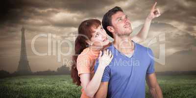 Composite image of happy couple looking upwards