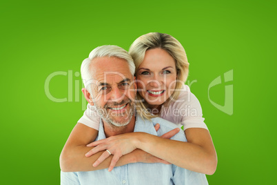 Composite image of smiling couple embracing and looking at camer