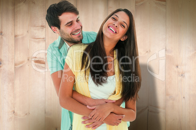 Composite image of happy casual couple smiling and hugging