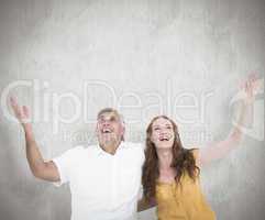 Composite image of casual couple smiling with arms raised