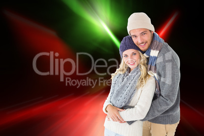 Composite image of attractive couple in winter fashion hugging