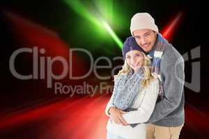 Composite image of attractive couple in winter fashion hugging