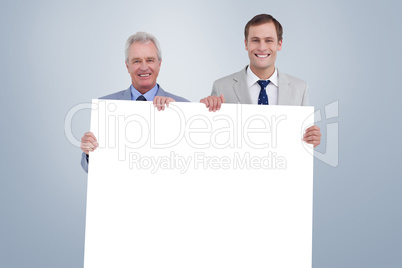 Composite image of smiling tradesmen holding blank sign