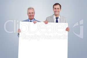 Composite image of smiling tradesmen holding blank sign