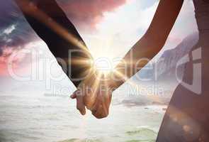 Composite image of mid section of newlywed couple holding hands
