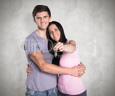 Composite image of young couple showing keys to house