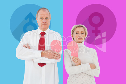 Composite image of older couple standing holding broken pink hea