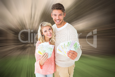 Composite image of attractive couple flashing their cash