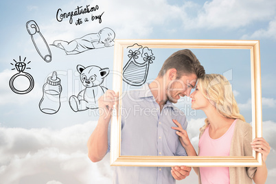 Composite image of attractive young couple holding picture frame